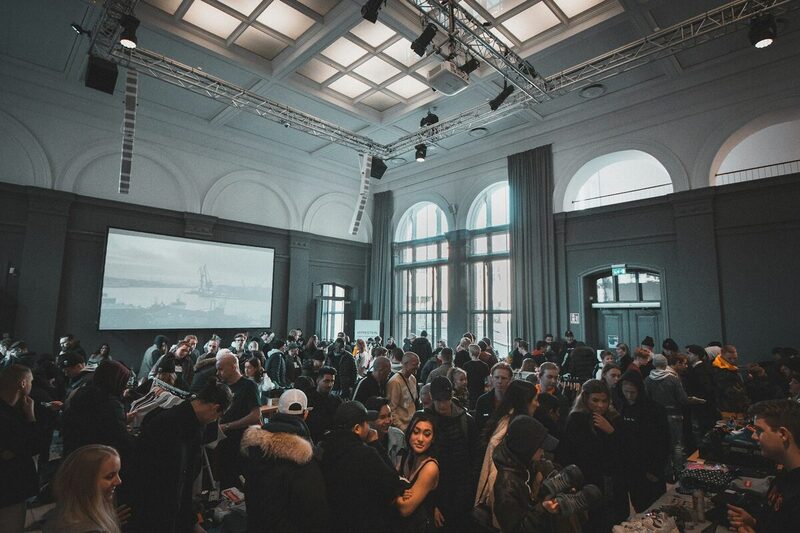 A large audience seated at a brand launch presentation in a bright venue