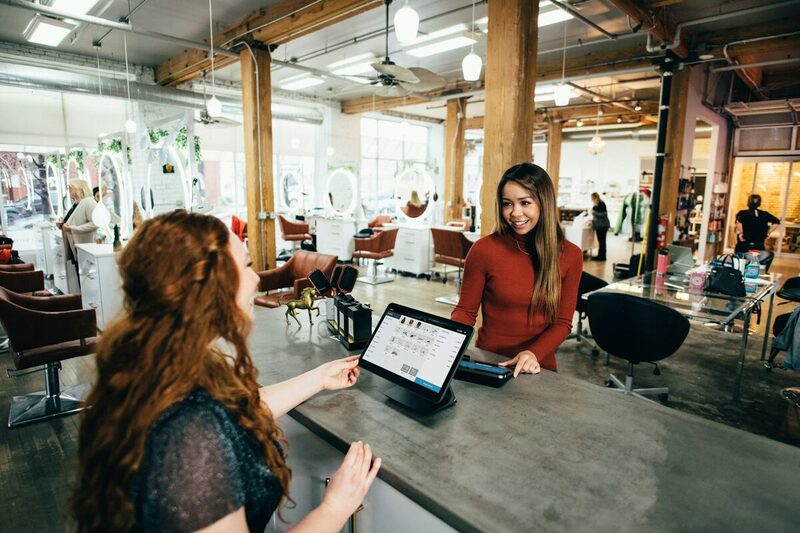 A brand ambassador serving a customer face to face at a retail counter